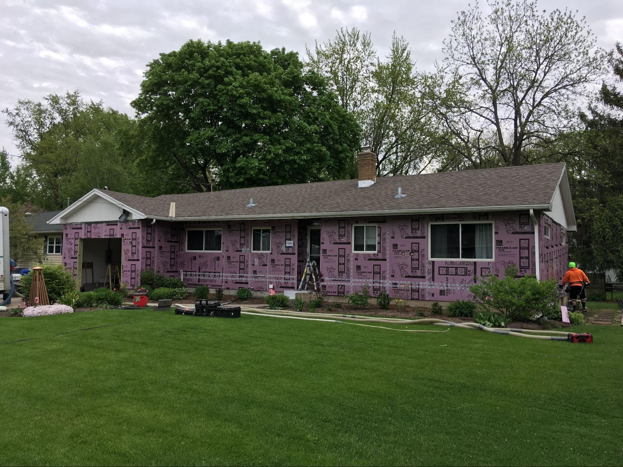 Exterior shot of house having dense packed wall insulation installed