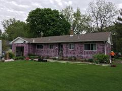 Exterior shot of house having dense packed wall insulation installed